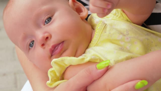 Schöne-drei-Monate-Baby-Mädchen-in-Müttern-Hände-liegen