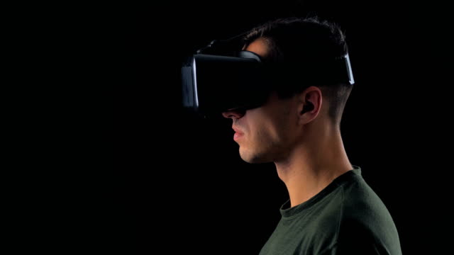 Porträt-des-jungen-Mannes-mit-VR-Brille-auf-schwarzem-Hintergrund.-Männliche-Virtual-Reality-Konsole-Headset-Play-3D-Gaming-Innovation-Internet-Entertainment-Technologie