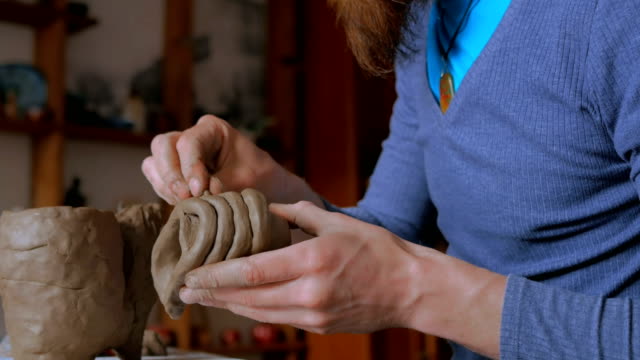Man-making-mug-in-pottery-studio-workshop