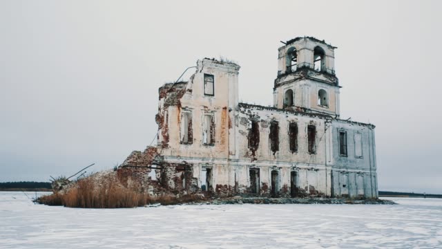 Abandoned-temple-building-in-middle-of-frozen-lake-covered-in-snow