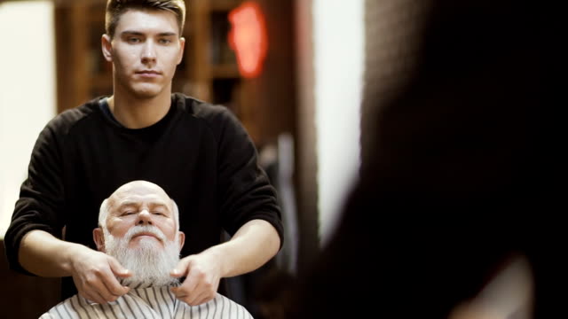 Barber-makes-stylish-beard-for-mature-man-in-barbershop