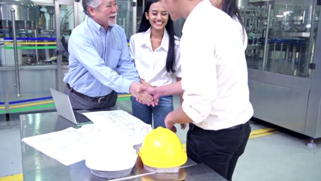 Factory-owner-inspecting-his-production-line.-Asian-senior-man-with-beautiful-asian-female-personal-assistants-and-engineer-talking-inside-factory.