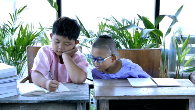 Gente-de-Asia-muchacho-dos-con-tareas-de-escritura.-concepto-de-educación