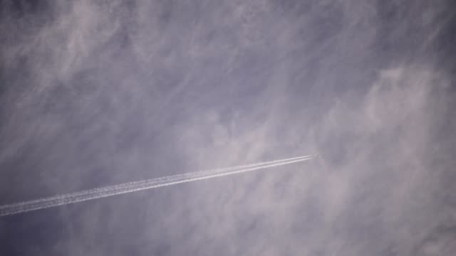 Aufnahmen-mit-einem-Teleobjektiv-ein-Flugzeug-fliegt-hoch-in-den-Wolken.