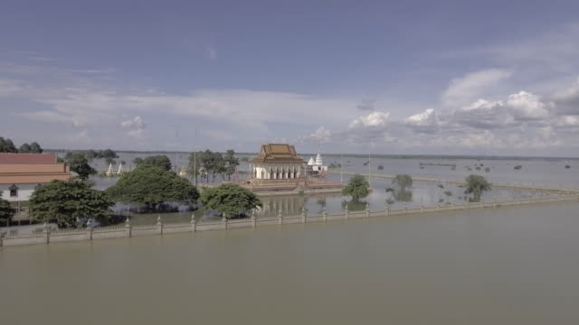 Aerial-static-view-of-a-pagoda-is-surrounded-by-floodwaters-under-cloudy-skies