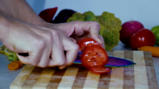 El-hombre-es-vegetales-de-corte-en-la-cocina,-cortar-tomate