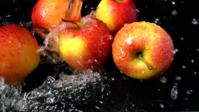 The-stream-of-water-flows-on-apples.-Slow-motion.