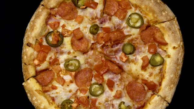 Rotation-der-leckere-schmackhafte-Pizza-auf-einem-schwarzen-Hintergrund