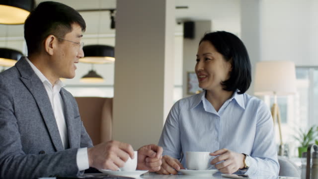 Man-and-Woman-Talking-over-Cup-of-Coffee