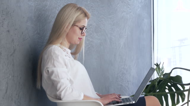 Mujer-que-trabaja-en-la-computadora-portátil-en-la-oficina