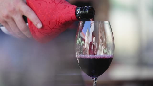 Red-Wine.-Waiter-Pouring-Wine-In-Glass-At-Restaurant-Closeup