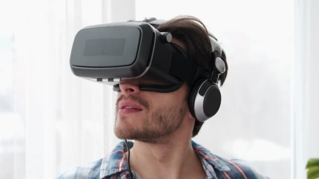 Young-man-using-his-virtual-reality-glasses