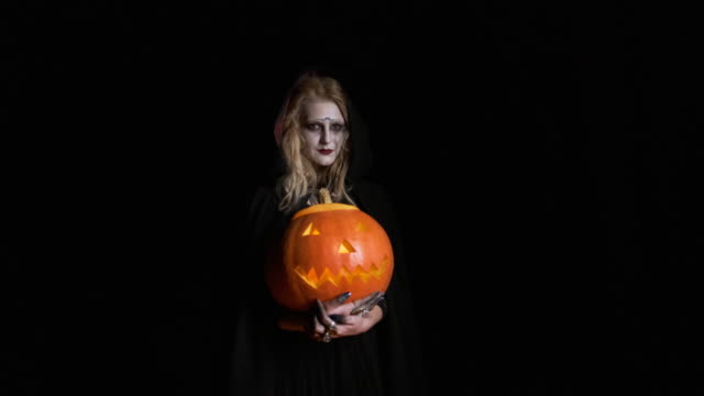 Halloween-Image-.Young-Witch-In-Black-Clothes-Holds-Pumpkin-In-Her-Hands.
