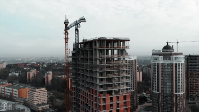 Unfinished-residential-complex-in-city-center.-Construction-crane-near-development-building.-Construction-works-in-metropolis