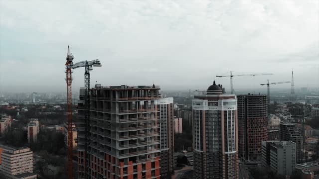 Aerial-view-of-high-rise-concrete-building-construction.-Residential-complex-construction-in-big-metropolis.-Drone-flying-near-unfinished-brick-building