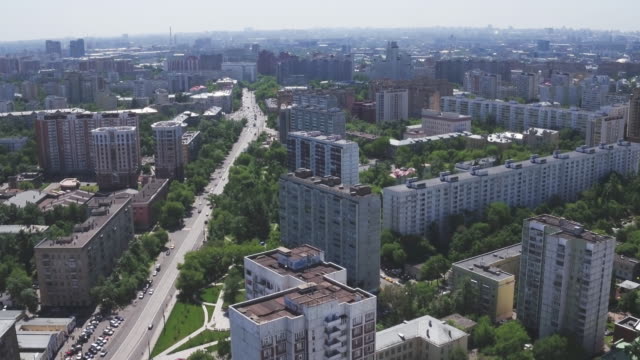 Panoramic-aerial-view-of-one-of-the-districts-of-Moscow-with-residential-buildings,-playgrounds,-kindergarten-and-road-traffic,-summer-weather.-Urban-cityscape-from-quadrocopter