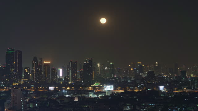 Vista-aérea-de-Sathorn-con-luna-llena,-Bangkok-Downtown,-Tailandia.-Distrito-financiero-y-centros-de-negocios-en-la-ciudad-urbana-inteligente-en-Asia.-Rascacielos-y-edificios-de-gran-altura-por-la-noche.