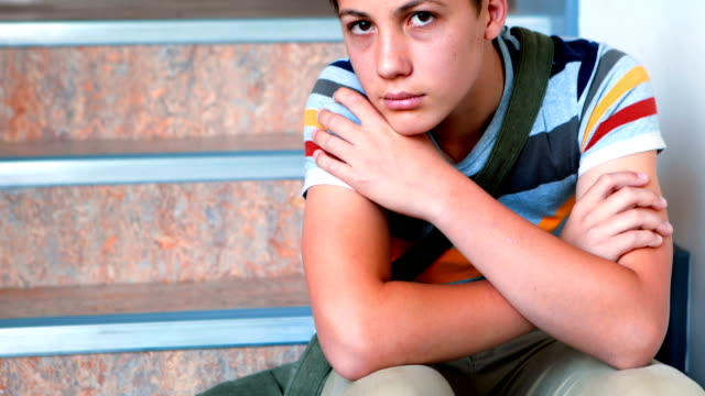 Sad-schoolboy-sitting-alone-on-staircase