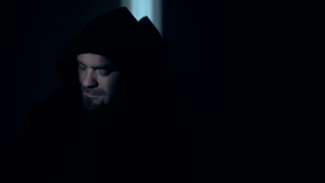 Portrait-of-sad--thoughtful-hooded-young-man-in-darkness