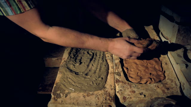 Potters-hands-remove-a-half-dry-slab-of-clay-from-the-mold.
