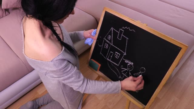 Woman-draw-home-and-family-on-blackboard