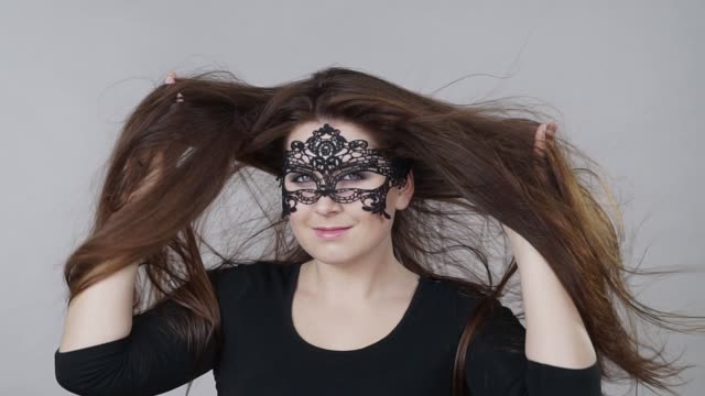 Mujer-con-máscara-de-carnaval-cabello-largo-soplar