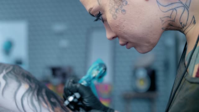 woman,-a-tattoo-artist,-does-a-tattoo-in-the-salon.