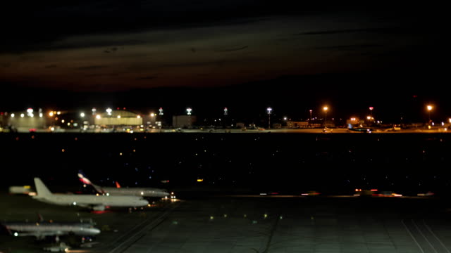 Timelapse-del-aeroplano-y-del-carro-tráfico-en-aeropuerto-de-Sheremetyevo-en-Moscú-por-la-noche,