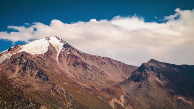 Summer-landscape-in-mountains-and-dark-blue-sky.-Time-lapse.-Stock.-Timelapsed-scenery-with-mountain-peaks-and-cloudy-sky