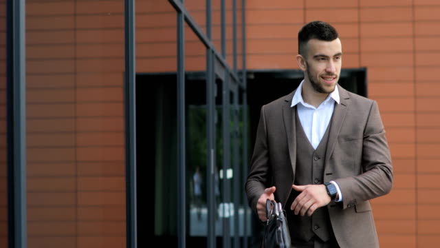 Businessman-Walking-on-Streets-of-Business-District-and-see-time