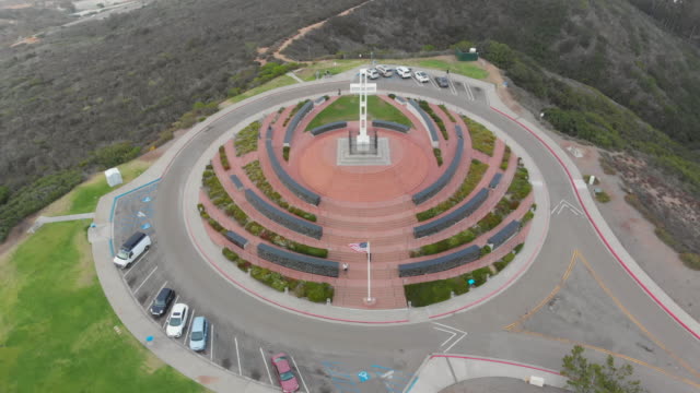 Mt.-Soledad-Overhead-High-Aerial-Drone-View-Looking-Down-on-the-Cross-Monument-with-Cars,-Grass,-Trees,-and-Hills-in-View