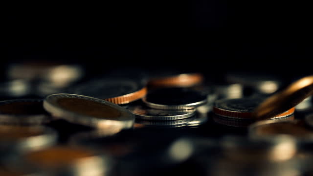 Close-up-slow-motion-Thai-Baht--money-coin-falling-to-the-floor-in-dark-light-,-business-and-financial-for-money-saving-or-investment-background-concept-with-black-copy-space-,-extremely-close-up-and-shallow-DOF