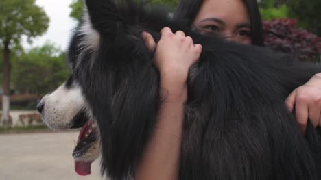 Happy-young-asian-woman-holding-her-dog-alaskan-malamute-outdoor,4k