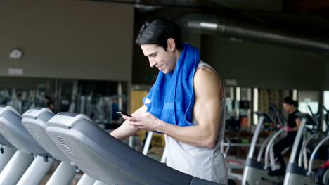 Un-chico-sin-camiseta-en-el-gimnasio,-entrena-su-cuerpo-para-mantenerse-en-forma-y-han-definido-los-músculos.-El-atleta-provoca-fatiga-y-cargas-pesadas.