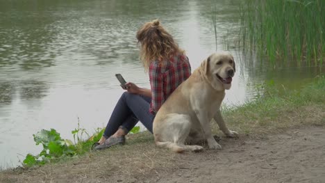 Young-woman-and-labrador-is-sitting-back-to-back