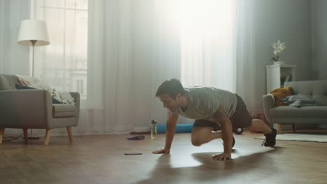 Athletic-Fit-Man-in-T-shirt-and-Shorts-is-Doing-Mountain-Climber-Exercises-While-Using-a-Stopwatch-on-His-Phone.-He-is-Training-at-Home-in-His-Bright-Apartment-with-Minimalistic-Interior.
