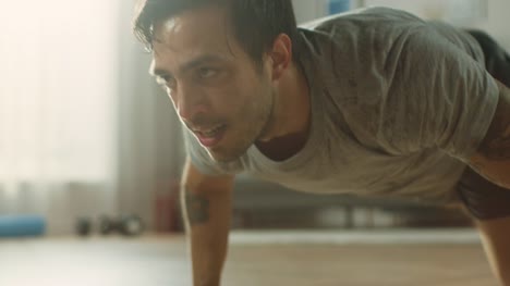 Slow-Motion-Close-Up-of-a-Muscular-Fit-Man-in-T-shirt-and-Shorts-is-Doing-Mountain-Climbers-While-Using-a-Stopwatch-on-His-Phone.-He-is-Training-at-Home-in-His-Apartment-with-Minimalistic-Interior.