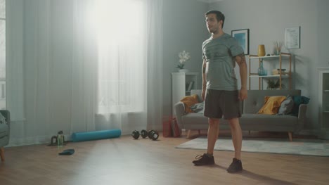 Muscular-Athletic-Fit-Man-in-T-shirt-and-Shorts-is-Doing-Squat-Exercises-at-Home-in-His-Spacious-and-Bright-Apartment-with-Minimalistic-Interior.