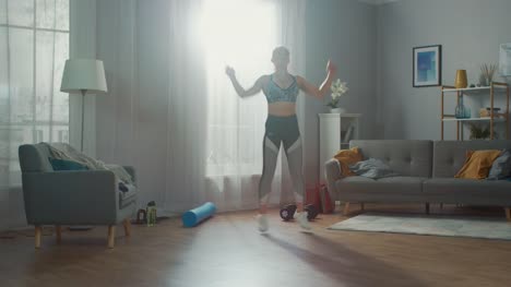 Strong-and-Beautiful-Fitness-Girl-in-an-Athletic-Top-is-Doing-Jumping-Jack-Exercises-in-Her-Bright-and-Spacious-Living-Room-with-Minimalistic-Interior.