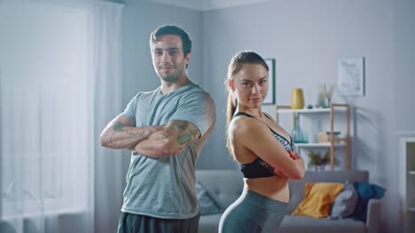 Muskulöser-sportlicher-Mann-und-schöne-Fitness-Frau-in-Trainingskleidung-sind-vertraulich-posiert-in-ihre-helle-und-geräumige-Wohnung-mit-minimalistisches-Interieur.