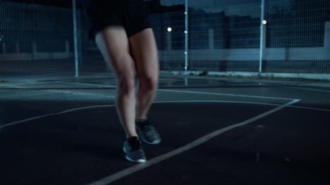 Close-Up-of-a-Beautiful-Energetic-Fitness-Girl-Doing-Footwork-Running-Drill.-She-is-Doing-a-Workout-in-a-Fenced-Outdoor-Basketball-Court.-Night-Footage-After-Rain-in-a-Residential-Neighborhood-Area.