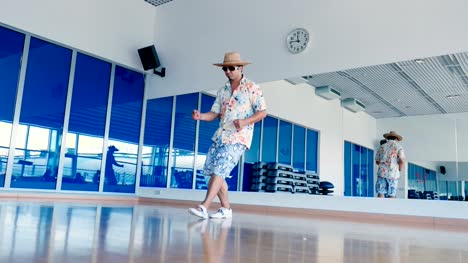 Funny-man-in-sunglasses-and-hat-dancing-in-gym