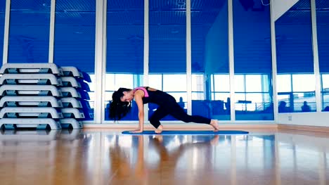 Schöne-Frau-trainiert-Flexibilität-im-Fitnessstudio-auf-der-Matte