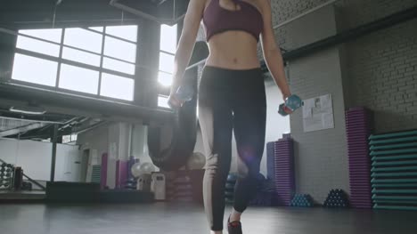 Sportswoman-with-Dumbbells-Doing-Jump-Lunges-in-Gym