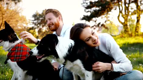 Beautiful-couple-cuddling-and-walking-dogs-outdoors