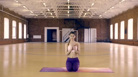 Junge-Frau-entfaltet-sich-eine-Yoga-Matte