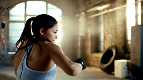 Schöne-sportliche-Frau-Schläge-Luft-mit-ihren-Fäusten-als-Teil-ihrer-intensiven-Cross-Fitness-Fitness-Training.