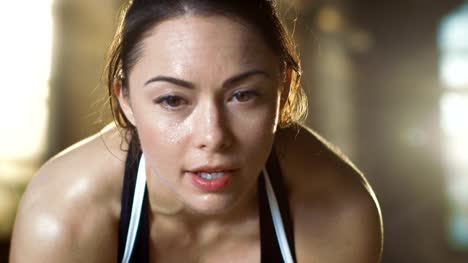 Beautiful-Athletic-Woman-Wipes-Sweat-from-Her-Forehead-with-a-Hand,-Looks-into-Camera.-She's-Tired-after-Intensive-Cross-Fitness-Exercise.