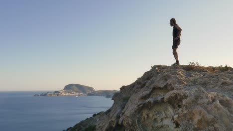 Running-man-arrives-on-top-of-a-cliff-on-an-island-in-front-of-the-ocean