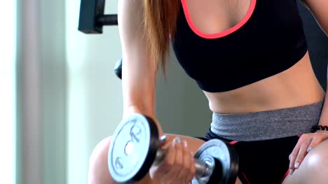Young-woman-exercise-with-dumbbell-at-sport-club
